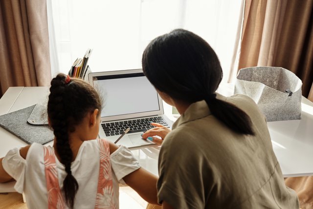 mother helping her daughter with homework 4260475